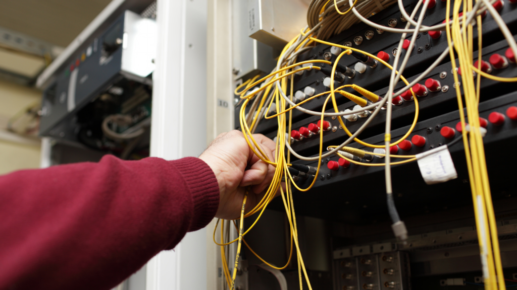 Fibre optic technician configuring fibre optic on ODF at telecom site