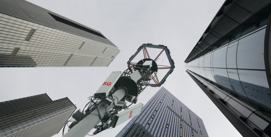 5G transmission tower in downtown with corporate buildings