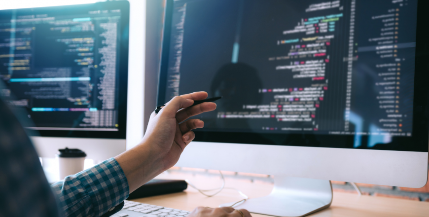 Software radio engineer points to computer screen using pen and analyzes the code