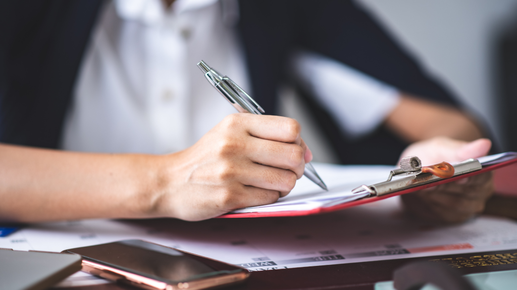 Telecom executive taking a certification exam on a clipboard paper with a pen