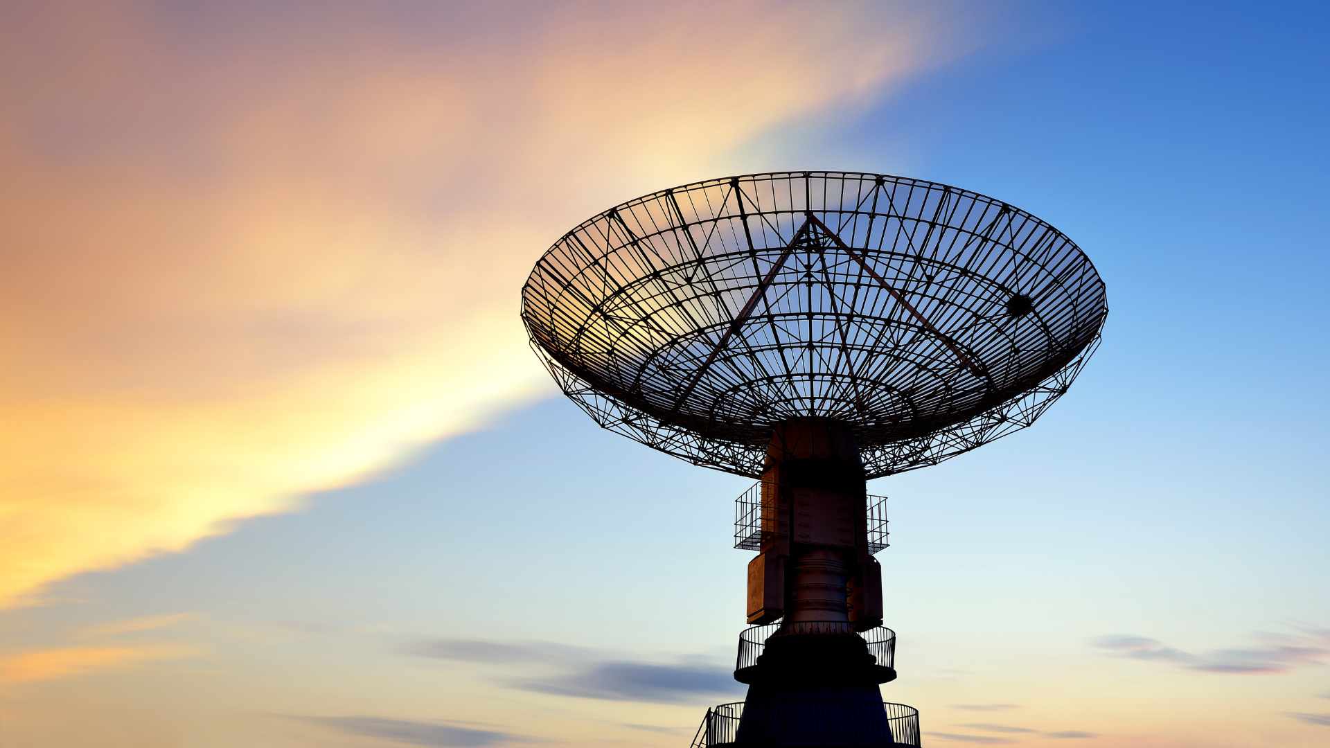 Satellite dish against sunset skies