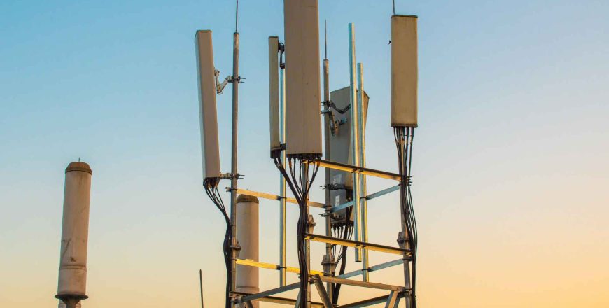 5G communications tower against sunset background