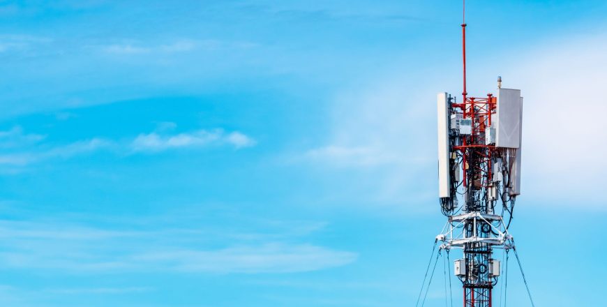 Telecommunications tower against blue sky and clouds