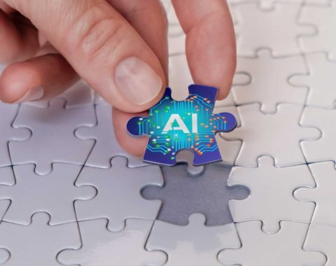 A hand places the last piece of the puzzle piece labelled AI