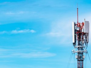 Telecommunications tower against blue sky and clouds