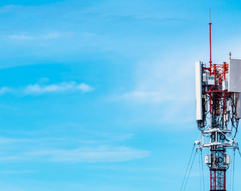 Telecommunications tower against blue sky and clouds