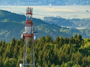 A microwave tower at the top of a hill on an aerial shot