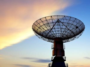 Satellite dish against sunset skies