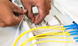 A pair of hands installing fiber optic cables