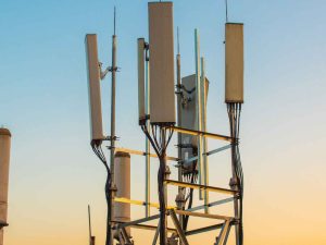 5G communications tower against sunset background