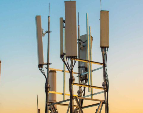 5G communications tower against sunset background
